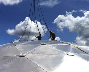 Installers on top of a geodesic dome roof