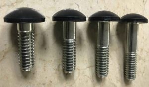 Four bolts with plastic caps laying on a marble surface