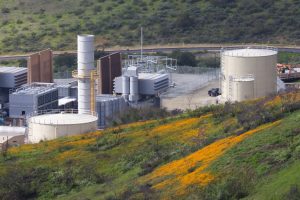 Three epoxy bolted tanks in front of a hill of flowers