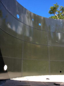 Inside olive green glass fused to steel tank with openings in the plates.