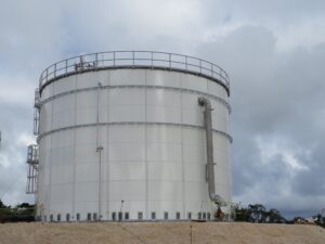 White Bolted Panel Storage Tank with large pipe and cloudy sky