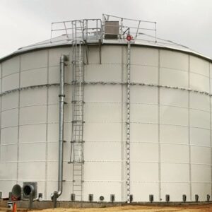White panel tank with a level indicator, ladder with safety cage and overflow pipe.