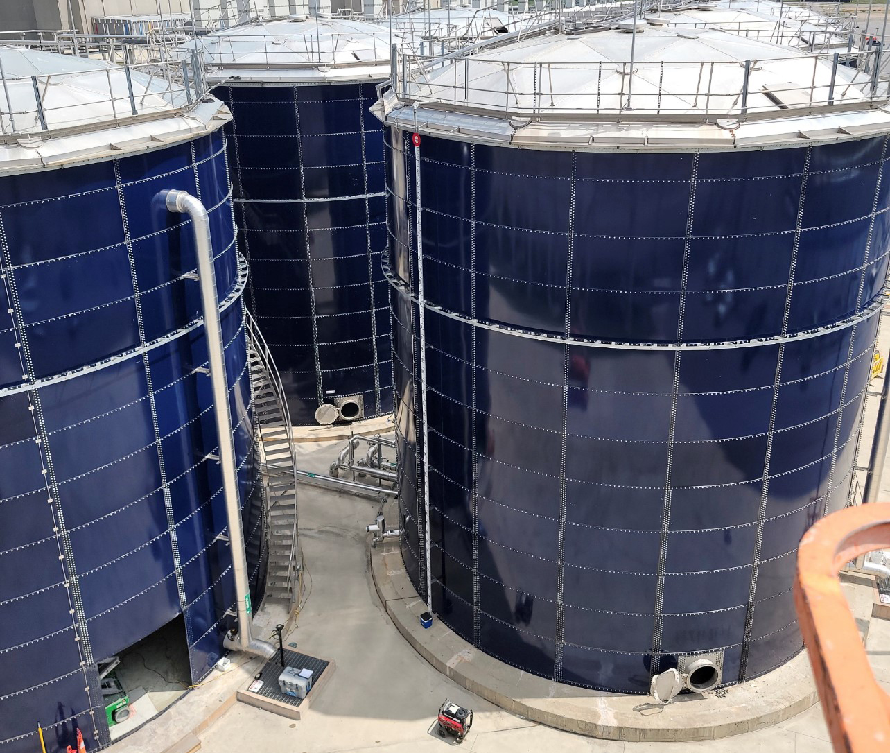 Cobalt blue water storage tanks with domes and safety rails