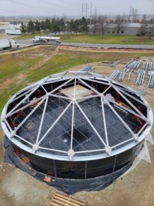 Looking down on aluminum dome beams on top of a black water tank