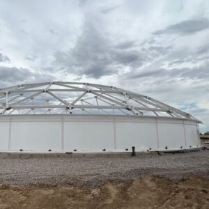 White bolted tank panels and aluminum dome frame on industrial job site