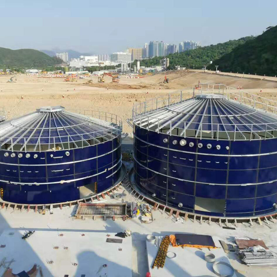 Two blue storage tanks with roofs with steel girders
