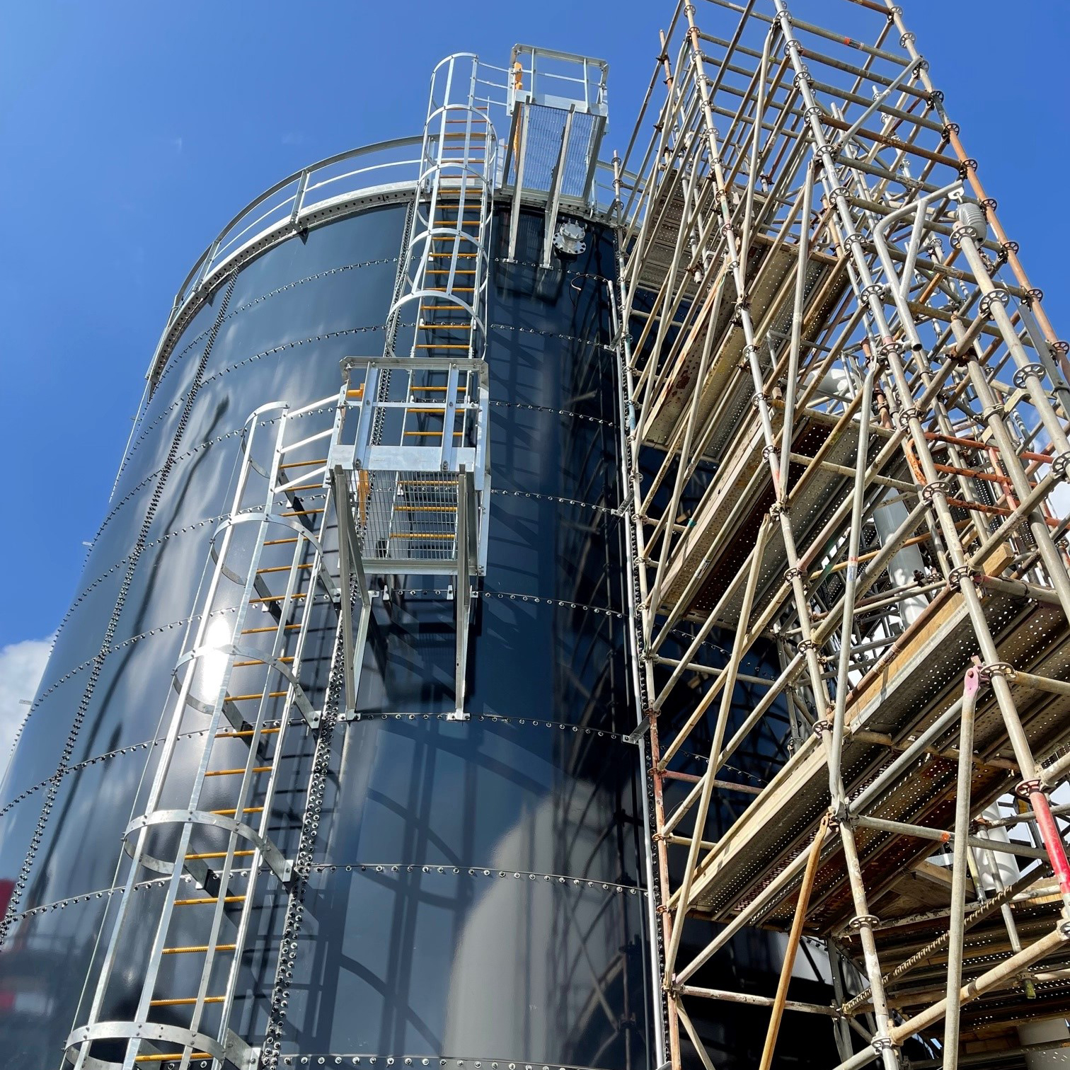 Blue waste water storage tank with scaffolding and external ladder